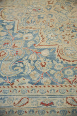 Evenly worn, low pile of a vintage Meshed carpet showing dusty blue and rust floral motifs.