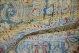 Soft folds of a vintage Meshed carpet reveal its low pile, distressed texture, and patterns in dusty blue and cream.