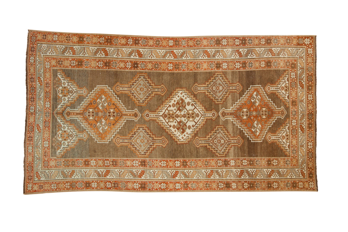 Vintage distressed Kurd rug with stepped medallions in rust and ivory on an abrashed coffee brown field.
