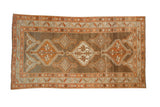 Vintage distressed Kurd rug with stepped medallions in rust and ivory on an abrashed coffee brown field.