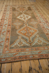 Low angle view down the length of the distressed Kurd rug's geometric medallion column.