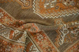 The soft, flexible weave of a distressed Kurd rug with rust, ivory, and brown geometric patterns.