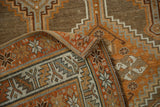 A vintage Kurd rug's corner folded to show the machine-bound edge, short fringe, and weave.