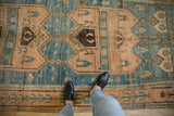 The worn, low pile and primitive medallions of a distressed vintage Bijar rug runner shown underfoot.