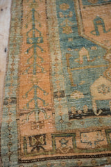 Worn knot heads and visible foundation on a distressed Bijar runner in sky blue and rose.