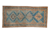 Distressed Persian Malayer runner with a column of geometric diamond medallions in sky blue and pale coffee brown.
