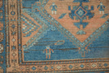 Pictorial human figures woven in the sky blue and coffee brown field of a distressed Malayer rug.