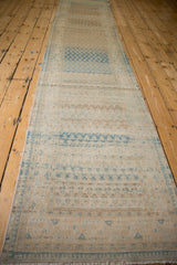 Perspective view of a long vintage Mir Sarouk runner showcasing its bands of color and distressed texture.