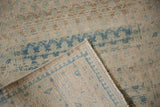 Corner detail showing the hand-knotted foundation and machine-bound edge of the vintage runner.