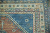 Detailed view of the layered geometric and floral borders on a distressed Caucasian rug.