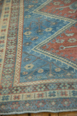 A close view of the softly worn pile and geometric border on a vintage Caucasian rug.