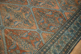 Diamond lattice field and detailed boteh border of an antique Malayer carpet in terracotta and blue.
