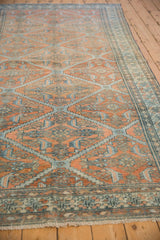 Angled perspective showing the allover stepped lattice design on a distressed antique Malayer carpet.