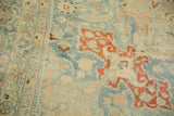 Close view of the distressed low pile texture, showing curled botehs in cinnabar red on a slate blue field.