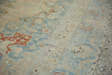 Soft, low pile of a distressed Tabriz carpet with pale blue and cinnabar red boteh motifs.