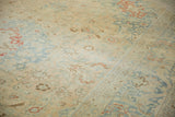 Time-softened slate blue and dusty rose tones on the distressed, low pile of a vintage carpet.