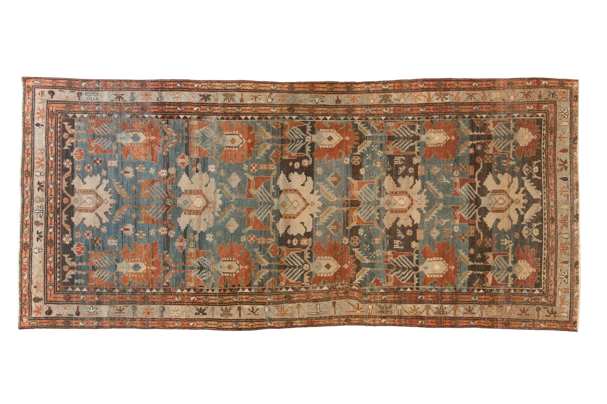 Antique Persian Mehreban runner with repeating oversize palmettes in dusty teal, chestnut, and ivory tones.