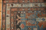 Boteh motif border in dusty teal and chestnut on a distressed antique Mehreban rug corner.