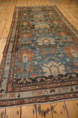 Angled view of an antique Mehreban runner highlights time-softened tones across its palmette design.