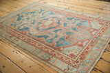 Vintage Distressed Malayer rug corner with softened red, sky blue, and ivory geometric border patterns.