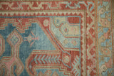 Distressed vintage Persian Malayer rug border detail with powder blue and red geometric motifs.