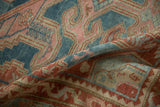 Distressed Malayer rug with powder blue, dusty red, and beige geometric patterns.
