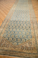 Angled view of a distressed Hamadan runner showing its boteh pattern on an abrashed blue ground.