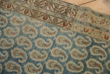 Staggered boteh pattern in dusty blue and sand on a distressed, low-pile Persian runner.