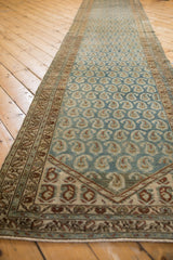 Angled view of the vintage Hamadan runner's abrashed blue field and staggered boteh pattern.
