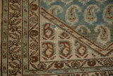 Corner of a distressed Hamadan runner with copper boteh motifs and worn, low-pile texture.