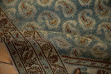 A soft fold in the vintage Persian runner reveals its worn texture and dusty blue botehs.