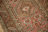 Geometric blossoms and a serrated leaf border on a distressed Heriz rug with a low, worn pile.