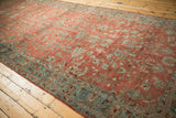 Angled view of a vintage Bibikabad carpet's sprawling floral design in dusty teal and pomegranate red.