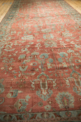 Low pile texture of a vintage Bibikabad runner with a sprawling floral design in red and teal.