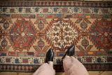 Close-up of a vintage Serab rug's geometric medallion with hook and latch outlines and pawn borders.