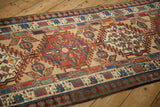 Angled perspective on a vintage Serab runner's intricate pawn and germinating blossom borders.