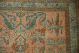 Detailed view of sprawling floral arabesques and geometric borders in teal, rust, and dusty blush.