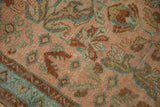 Evenly worn pile of a Lilihan rug showing dusty teal and rust floral motifs on a blush field.