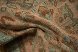 Distressed knot-head texture of a vintage rug in dusty blush, teal, and rust floral arabesques.