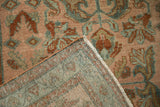 A folded corner on a vintage Lilihan rug reveals its hand-knotted foundation and secured side selvage.