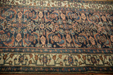 Detailed shot of an antique Bijar's indigo herati field and geometric vine border.