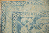 Close-up of the hand-knotted texture and side cord on a distressed Persian rug corner.