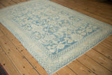 High-angle view of the distressed Hamadan rug's powder blue and cream floral lattice.