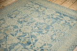 Worn pile revealing knot heads and foundation of a distressed blue and ivory Hamadan rug.