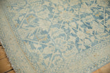 Corner of a distressed vintage Hamadan rug showing the worn pile and powder blue seed border.