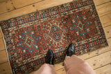 Vintage Karaja runner corner, highlighting brick red, sky blue geometric border, and intact side cord.