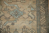 Close-up of a vintage Heriz rug's worn pile with geometric serrated leaves in powder blue.