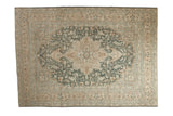 Vintage distressed Tabriz carpet with a large Heriz-style medallion in dusty teal, cream, and pale brown.