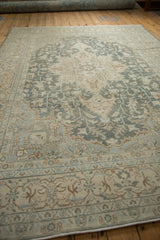Angled view of a vintage Tabriz rug showing even wear across its sprawling geometric pattern.