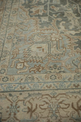 Low, even pile of a distressed Tabriz carpet showing pale teal and sand geometric motifs.